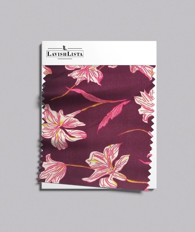 Floral cotton blend fabric swatch with pink lilies on maroon background
