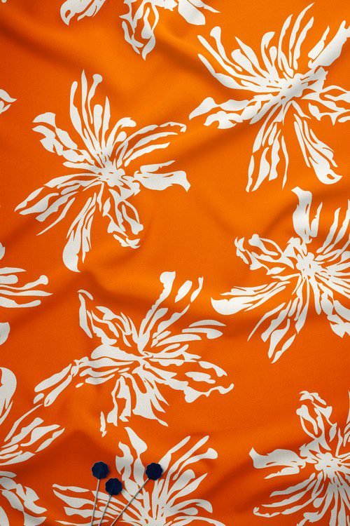 Bold white floral digital print fabric on orange base